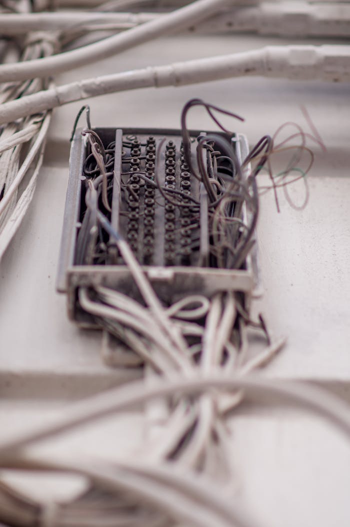 Detailed view of a tangled network of wires in a junction box, illustrating complex wiring.