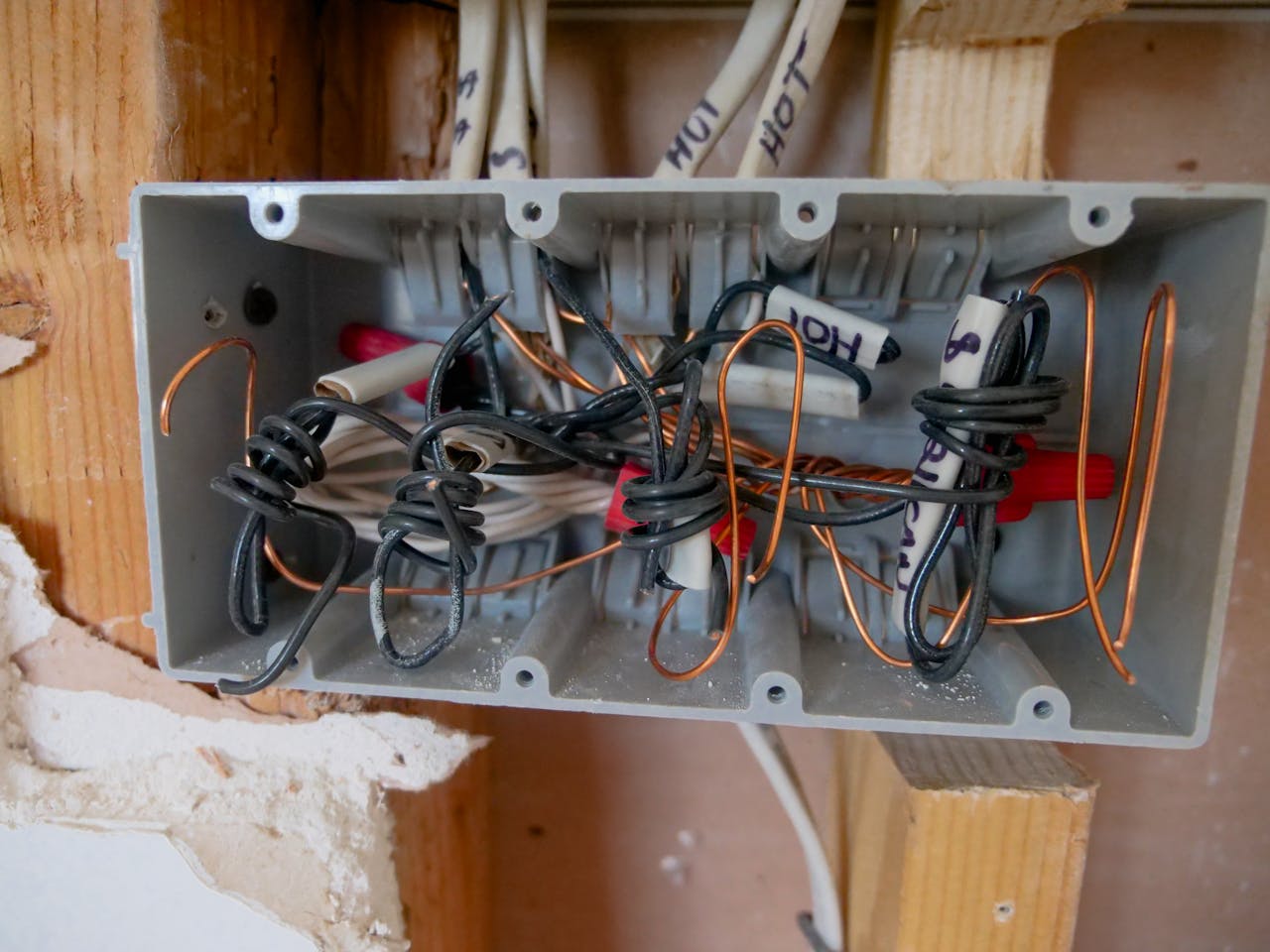 Detailed view of an open electrical switchboard with tangled wires and cables.